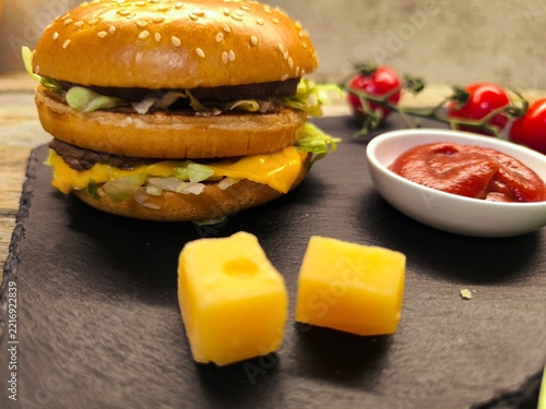An appetizing, delicious homemade burger made from minced beef on a wooden table.