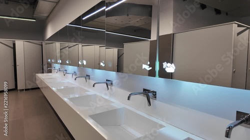 Modern Public Restroom with Row of Toilet Cubicles