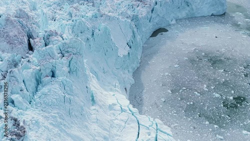Aerial view of the massive blue icebergs and jagged glacier walls of the Ilulissat Icefjord in Ilulissat, Avannaata, Greenland.