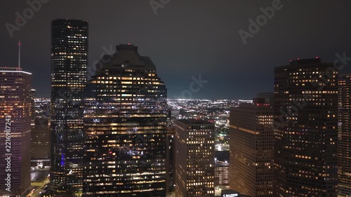 Aerial night view of Houston, Texas with dense commercial district and busy roadways. Modern illuminated buildings in city impressive skyline.