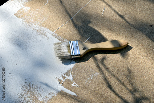 A wide paintbrush stained with oil paint, top view.