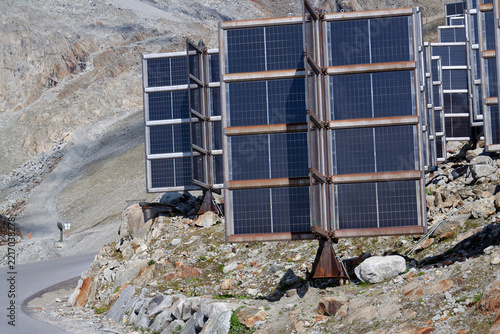 Detail of solar panels in mountains vertically mounted as four wings around central column like tree, photovoltaic plant avoid snow accumulation, future innovation energy concept