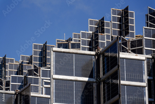 Detail of solar panels in mountains vertically mounted as four wings around central column like tree, photovoltaic plant avoid snow accumulation, future innovation energy concept