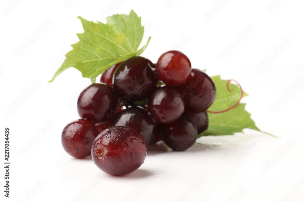 Fototapeta premium Fresh ripe grapes and green leaves isolated on white