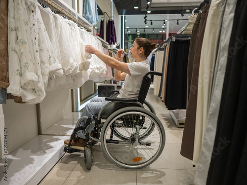 Fotografie A Caucasian woman in a wheelchair shopping at a mall.