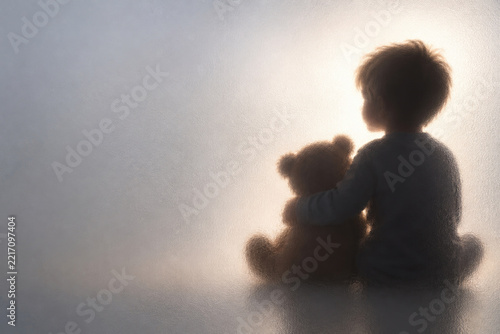 Child sits with a teddy bear behind frosted glass. Space for text.