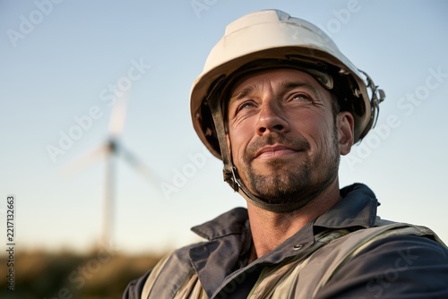 Confident wind turbine technician in white hard hat outdoors