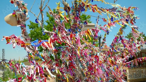 Colorful ribbons and traditional turkish evil eye amulets, known as nazar, hanging from a wishing tree and waving gently in the breeze in cappadocia, turkey