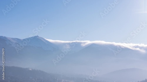 Aerial view of winter mountains showing snow-covered peaks and fog