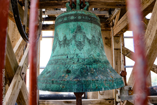 View of an ornate, oxidized bronze bell with intricate relief carvings housed within the wooden framework of the Hvar Cathedral bell tower in Hvar, Split-Dalmatia County, Croatia.