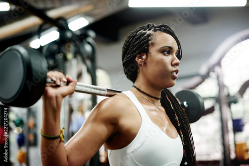 Fotografie Weightlifting, active or woman in gym with barbell for strength training, exercise or wellness