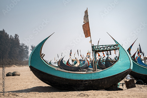 View of traditional wooden fishing boats resting on the sandy beach along the Cox's Bazar Marine Drive in Cox's Bazar, Chittagong Division, Bangladesh.
