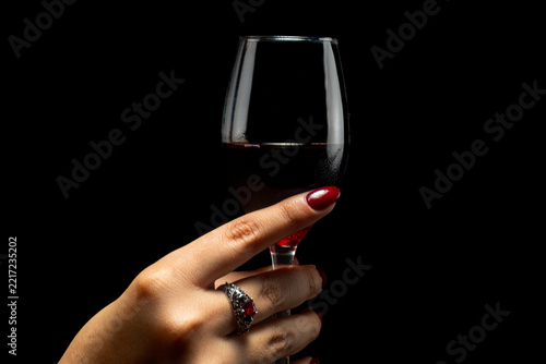 Elegant Female Hands with Burgundy Nail Polish and Vintage Ring on Black Background
