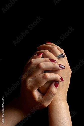 Elegant Female Hands with Burgundy Nail Polish and Vintage Ring on Black Background