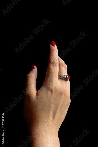 Elegant Female Hands with Burgundy Nail Polish and Vintage Ring on Black Background