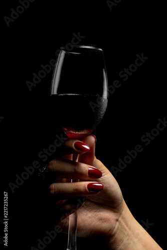 Elegant Female Hands with Burgundy Nail Polish and Vintage Ring on Black Background