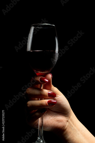 Elegant Female Hands with Burgundy Nail Polish and Vintage Ring on Black Background
