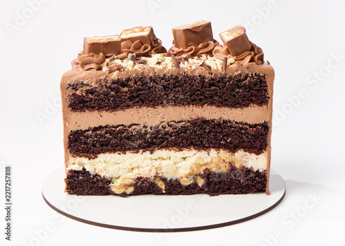 A beautifully layered chocolate cake decorated with chocolate bars and frosting.