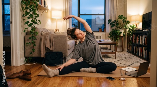 Woman practicing yoga at home in a cozy living room with plants and natural light