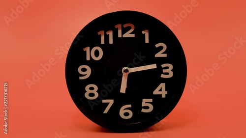 Time lapse video of a clock time passing over a day to night on orange background.