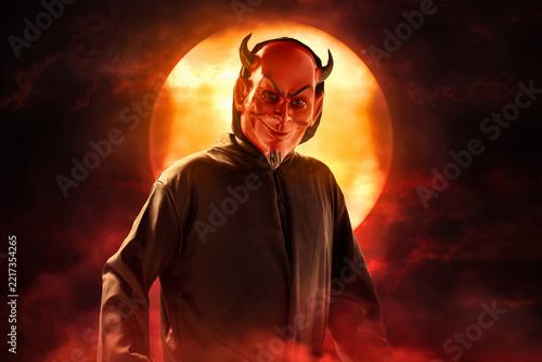 Red devil with horns at night with full moon and smoke mist fog, Halloween theme