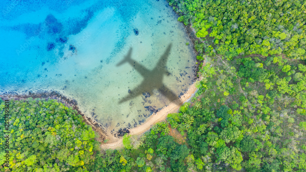 Naklejka premium Aerial view of shadow passenger plane silhouette and sandy beach blue sea with waves at sea beach summer vacation sea travel concept 