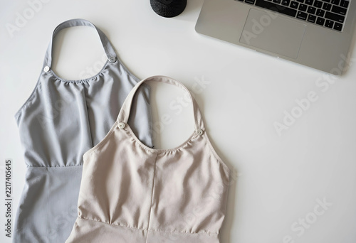 Fashion design and e-commerce business, two summer halter tops on a desk with a laptop for online clothing store management and retail marketing strategy