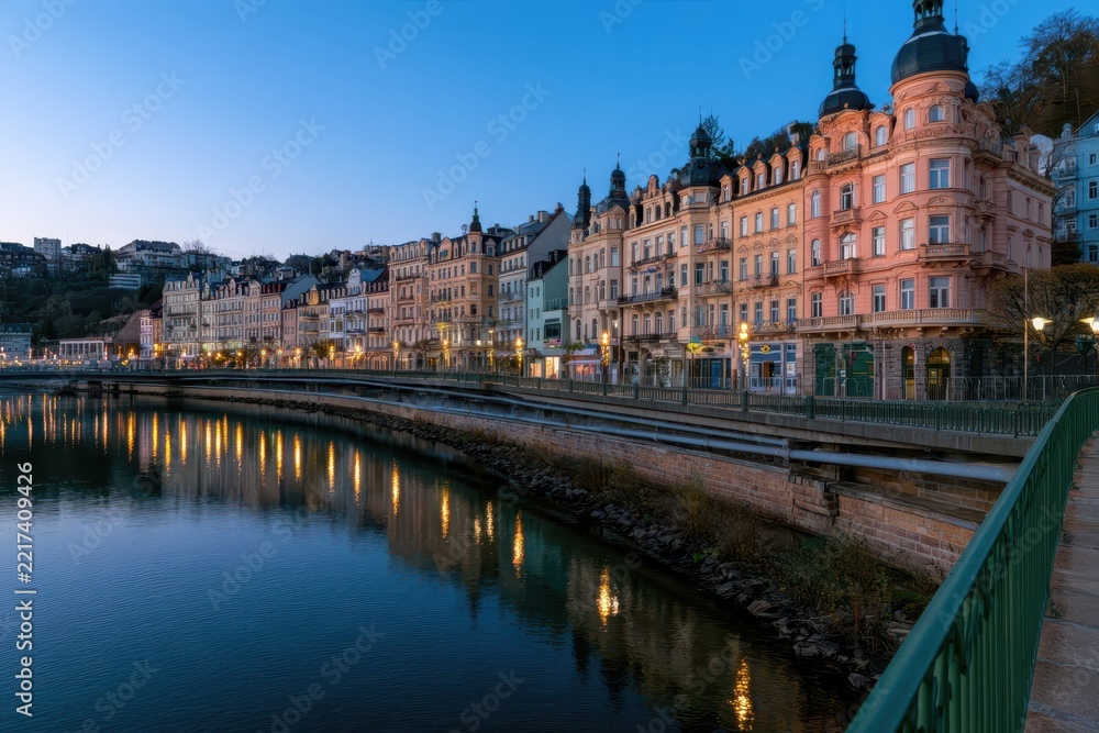 Fototapeta premium Row of historic buildings along a river at dusk