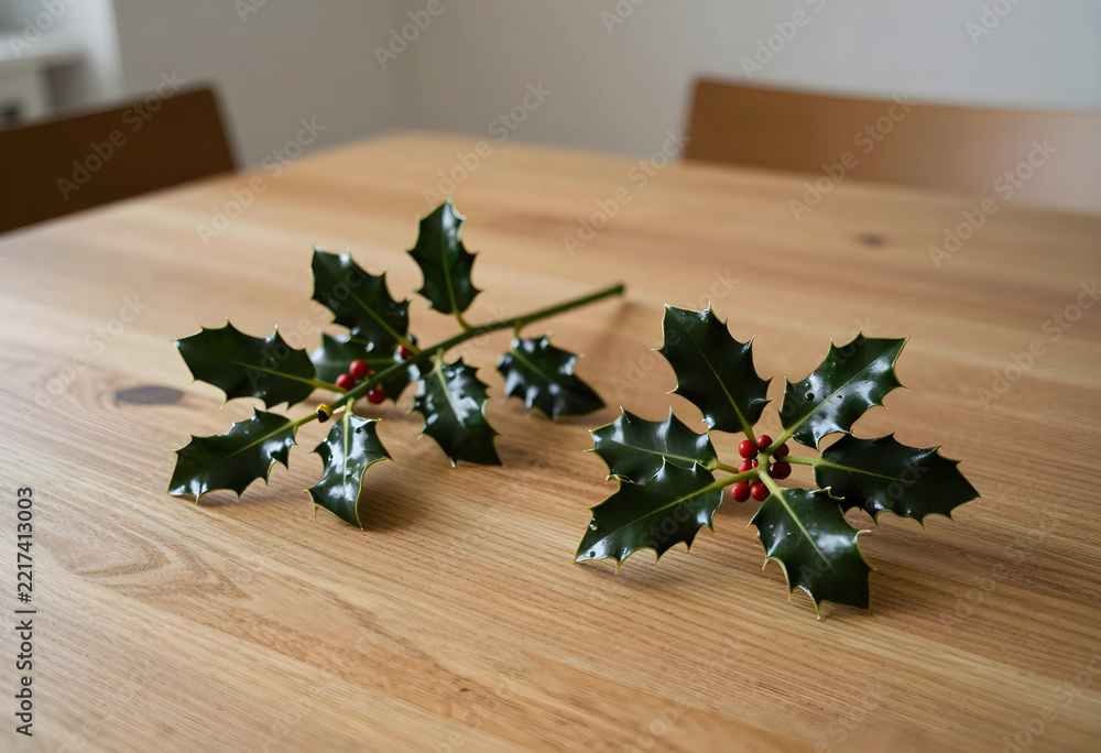 Fototapeta premium Christmas holiday decoration, holly sprigs with red berries on a wooden table for festive winter season home interior and seasonal celebration