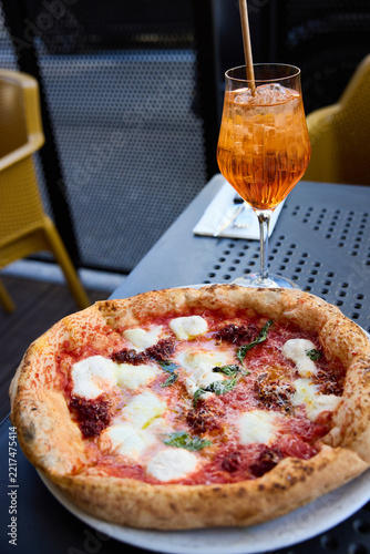 Delicious Neapolitan Pizza and Refreshing Aperol Spritz Cocktail on a Sunny Terrace