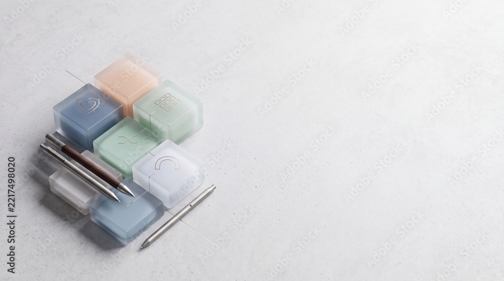 Fototapeta premium Minimalist Desk Composition with Frosted Glass Cubes and Professional Metallic Pens on Textured Gray Background with Copyspace for Business and Creative Design