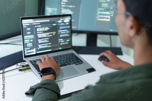 Over the shoulder view of a developer coding on a laptop