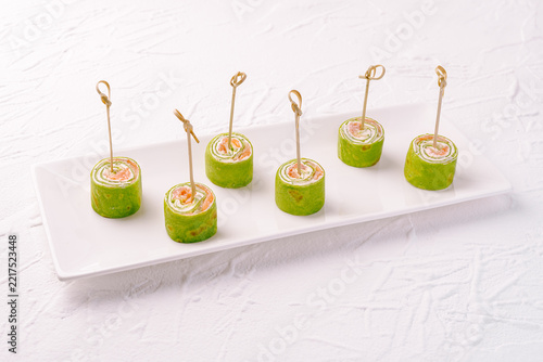 Spinach salmon cream cheese pinwheels on white plate