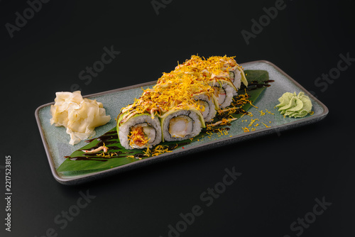 Sushi rolls with avocado and crispy topping on plate
