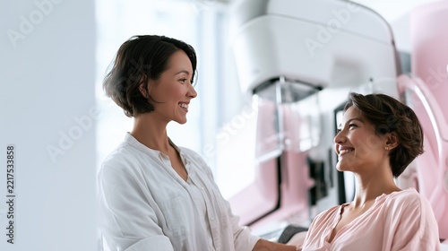 National Mammography Day: wide banner photograph of a female radiologic technologist calmly preparing a smiling woman patient beside a modern digital mammography unit