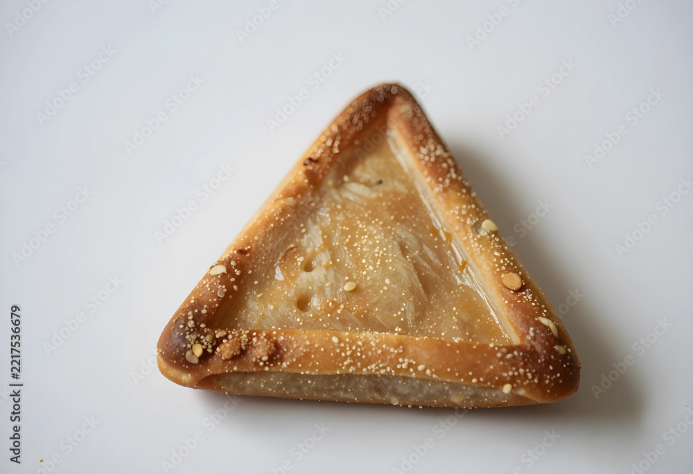 Fototapeta premium Purim celebration and Jewish holiday tradition, hamantaschen triangular cookie with poppy seed filling isolated on a clean white background