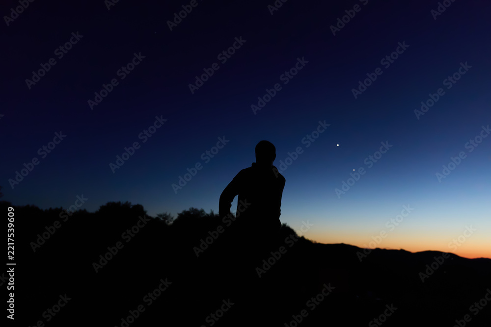 Fototapeta premium Amateur astronomer observing stars, planets, Moon and other celestial objects from a dark remote location in nature.