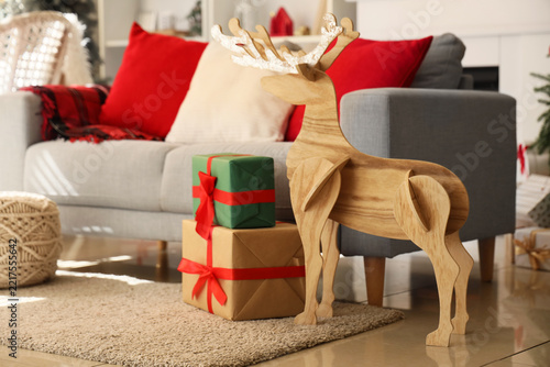 Cozy sofa, reindeer and gifts in Christmas interior of living room