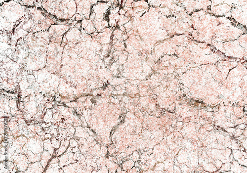 Wide textured background of cracked granite surface. Multicolored broken background of marble tiles. An abstract grunge texture with many chaotic cracks.