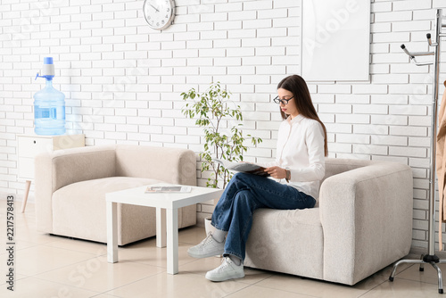 Waiting room anxiety and patient experience, woman reading magazine in medica...