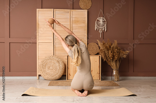 Mindfulness and wellness, woman practicing yoga with cork ball for flexibilit...