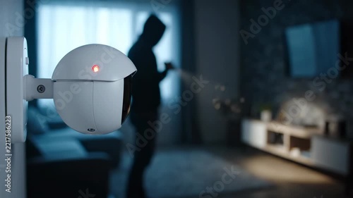 Home security camera records burglar in dark room, capturing suspicious activity at night