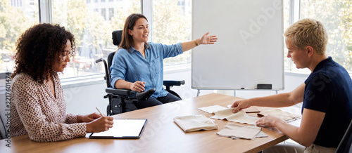 Woman in a wheelchair leading a fabric design meeting
