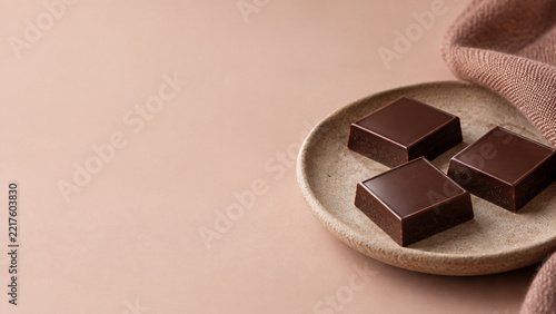 淡いピンクの背景に置かれた三粒のチョコレート