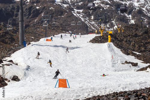 Skiers and snowboarders enjoy a groomed snow run at Whakapapa Ski Field on Mount Ruapehu, surrounded by volcanic terrain and alpine infrastructure in New Zealand