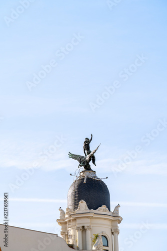 Bronze statue on dome against blue sky