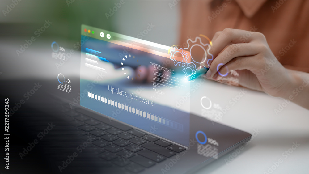 Fototapeta premium A software developer using a laptop and touching a virtual screen for software update progress, system maintenance installation, operating system upgrade, and modern digital data processing.