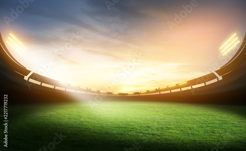 Football stadium background. Empty football stadium with green field and blur spotlights.