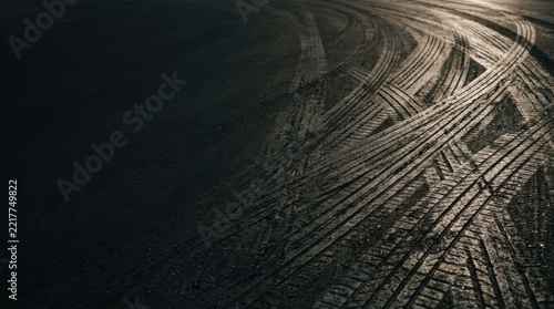 Tire tracks and skid marks on asphalt road surface close up