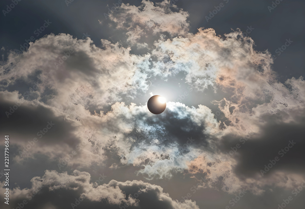Fototapeta premium Solar eclipse astronomy event, partial sun obscuration by moon with dramatic clouds in sky for scientific research and celestial phenomenon observation